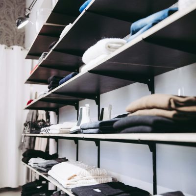 Neatly organized shelves with folded clothes in a contemporary store setting.